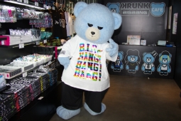 グッズコーナーの前でポーズをとるKRUNK