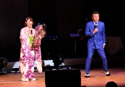花束をもって山口瑠美（右）の20周年記念コンサートのお祝いに駆け付けたパンチ佐藤（右）